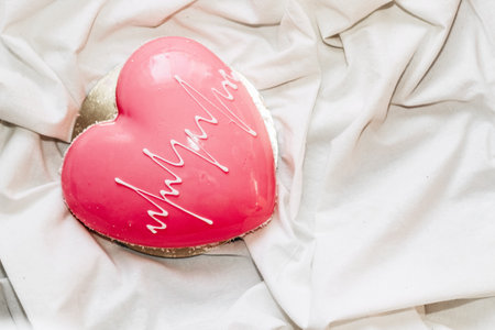 Heart shaped pink mousse cake on the table.の写真素材