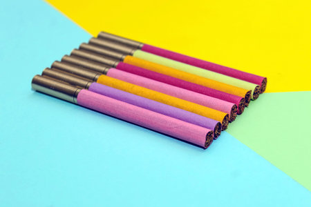 Multicolored cigarettes on a paper background, the concept of a bad habit.の写真素材