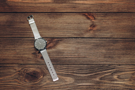 Wrist stylish watch with black dial on the table with brown planks.の写真素材