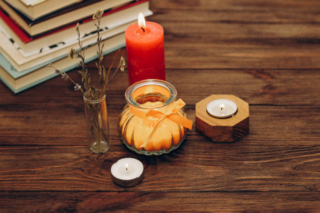 Still life with skins, Orange aroma candle in a figured candlestick with a bow and books on the background.の写真素材