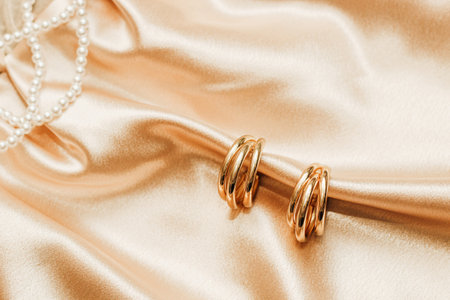 Women's jewelry, gold chain, trendy jewelry on a silk background.の写真素材