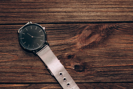 Wrist stylish watch with black dial on the table with brown planks.の写真素材