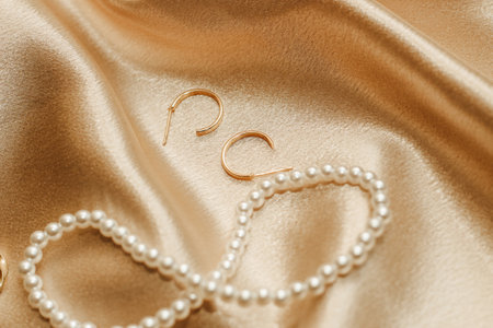 Women's jewelry, gold chain, trendy jewelry on a silk background.の写真素材