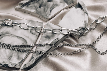 Stylish silver chain jewelry on the neck on a silk shiny background.の写真素材