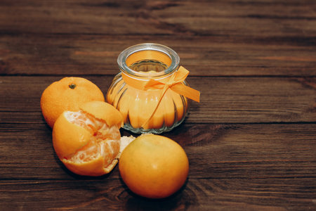Wax and aromatic orange candle in a candlestick stands on a wooden table.の写真素材