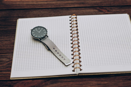 Open notebook diary with clock with black dial, time management concept.の写真素材