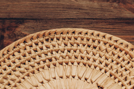 A wicker bowl for decor and fruits stands on a wooden brown table.の写真素材
