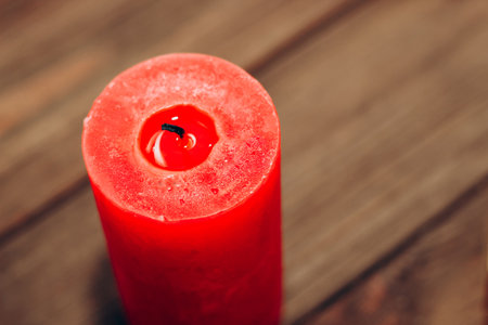 Red extinguished aroma candle on the background of wooden planks.の写真素材