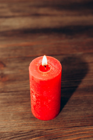 Red lit aroma candle on wooden boards background.の写真素材