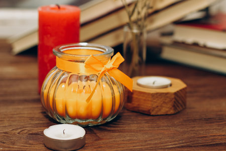 Still life with skins, Orange aroma candle in a figured candlestick with a bow and books on the background.の写真素材