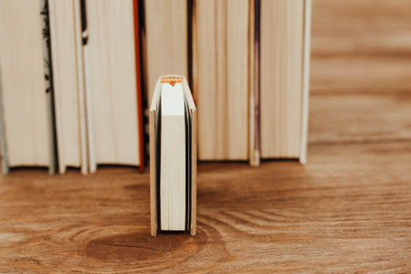 A stack of books stand on the tables, stacked in the frame, next to small mini books.の写真素材