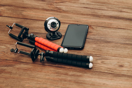 Two manual tripod monopods for a phone or a small camera on a wooden table.の写真素材