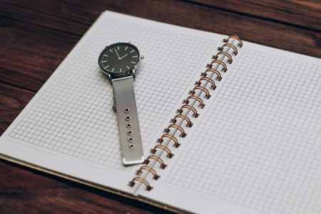 Open notebook diary with clock with black dial, time management concept.の写真素材