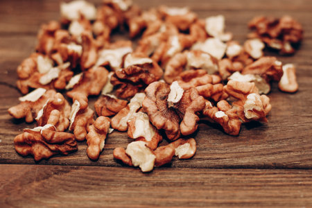 Dried walnut grains scattered on a wooden table.の写真素材