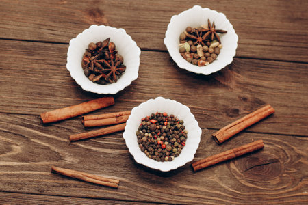 Spices anise, pepper, cumin, cumin, ginger in bowls on a wooden table.の写真素材