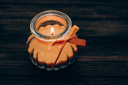 Orange aroma candle in a figured candlestick with a bow.の写真素材