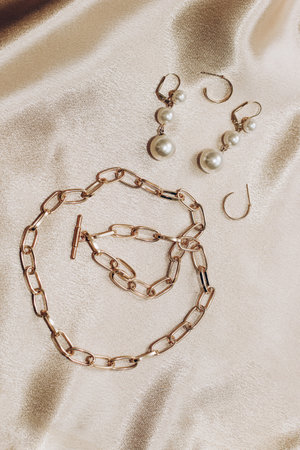 Women's jewelry, gold chain, trendy jewelry on a silk background.の写真素材