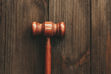 Judge's gavel on brown plank table, law and justice concept.の写真素材