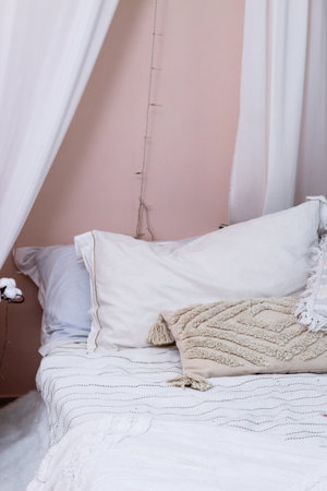 Decorative pillows on the bed in the bedroom as decoration of the interior and decor.の写真素材