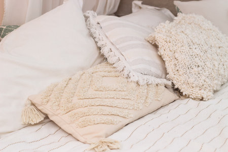 Decorative pillows on the bed in the bedroom as decoration of the interior and decor.の写真素材