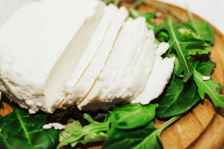 suluguni pickled cheese on a wooden board with herbs.の写真素材