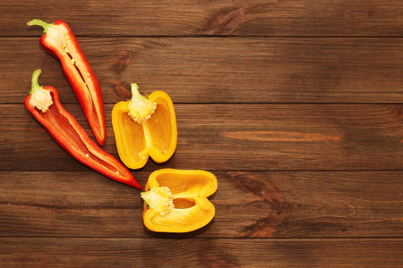 Red pepper Kapi with yellow sweet pepper on a wooden background, space for text.の写真素材