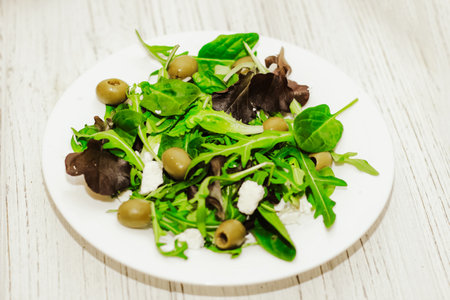 Salad leaves with arugula, cheese, green olives in a plate, healthy diet salad.の写真素材