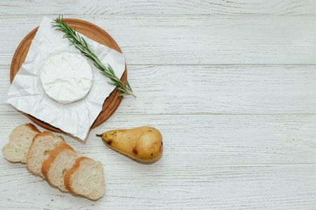 Camembert cheese with pear and rosemary sprig on the table.の写真素材
