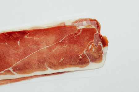 Pieces of dried pork jamon prosciutto on a white background.の写真素材