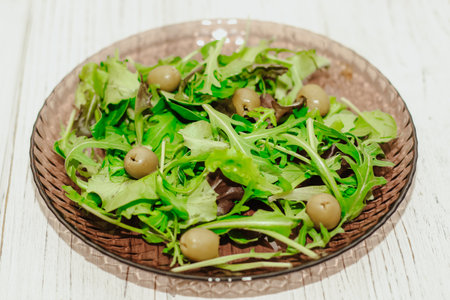 Salad leaves with arugula and green olives in a plate, healthy diet salad.の写真素材