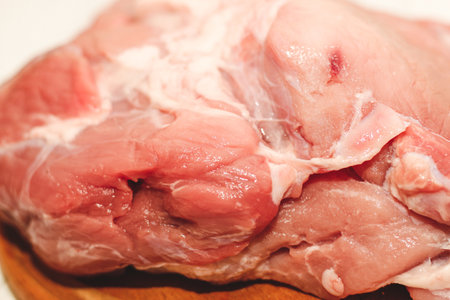Fresh piece of meat large pork ham on a board with pepper.の写真素材