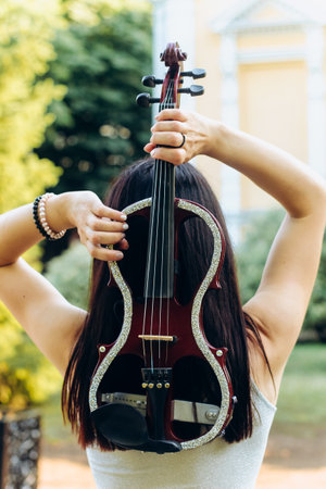 A fragment of an electric violin, a violin in the hands of a musician's girl.の写真素材