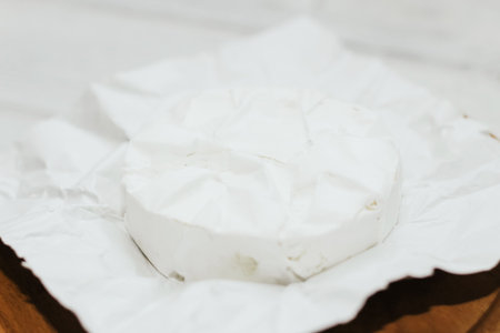 Camembert cheese unwrapped from packaging on the table.の写真素材