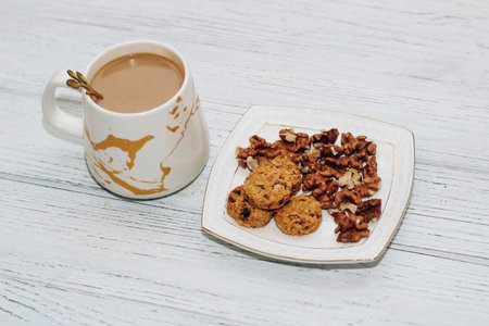 Healthy breakfast oat round granola with nuts on a plate and coffee, seed cookies.の写真素材
