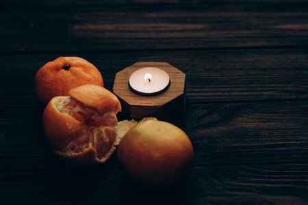 Wax and aromatic orange candle in a candlestick stands on a wooden table.の写真素材