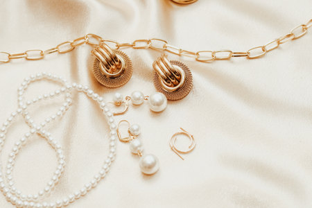 Women's jewelry, gold chain, trendy jewelry on a silk background.の写真素材