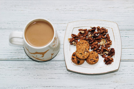 Healthy breakfast oat round granola with nuts on a plate and coffee, seed cookies.の写真素材