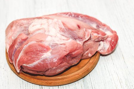 Fresh piece of meat large pork ham on the board.の写真素材