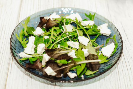 Salad leaves with arugula, cheese, green olives in a plate, healthy diet salad.の写真素材
