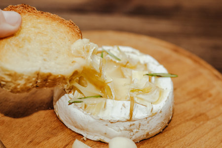 White baguette with olive oil and baked Camembert cheese on the table.の写真素材