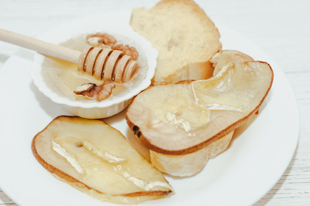 Camembert cheese with olive oil, rosemary, honey and baked pear.の写真素材