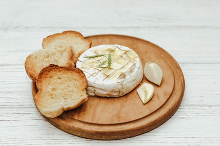 White baguette cut into pieces with olive oil and Camembert cheese on the table.の写真素材