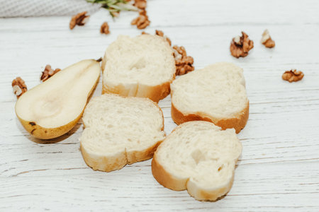 Pieces of ripe pear with toasted nuts on the kitchen table.の写真素材
