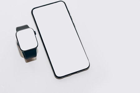 A black technological smart watch has a white screen for a place for text with a phone.の写真素材