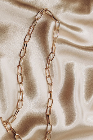 Women's jewelry, gold chain, trendy jewelry on a silk background.の写真素材
