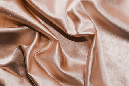 Golden shiny texture of silk satin satin with folds.の写真素材