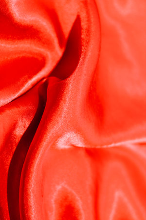 Red shiny texture of silk satin satin with folds.の写真素材