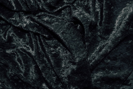 Texture of black velor corduroy fabric with folds.の写真素材