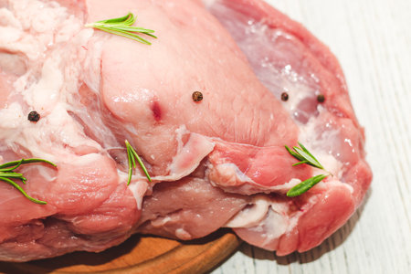 Fresh piece of meat large pork ham on a board with pepper.の写真素材