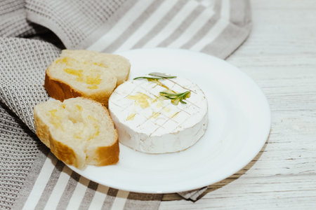 White baguette cut into pieces with olive oil and Camembert cheese on the table.の写真素材